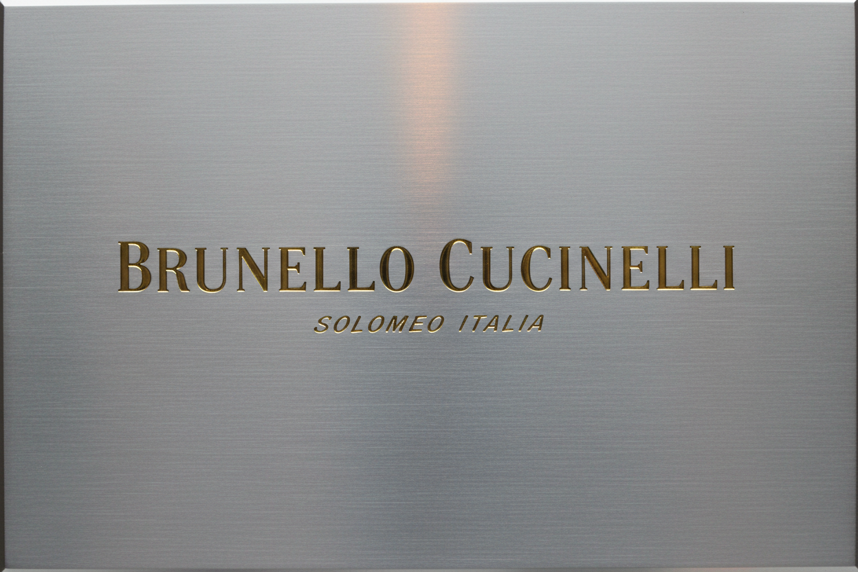 Brunello Cucinelli logo gold letters, silver background